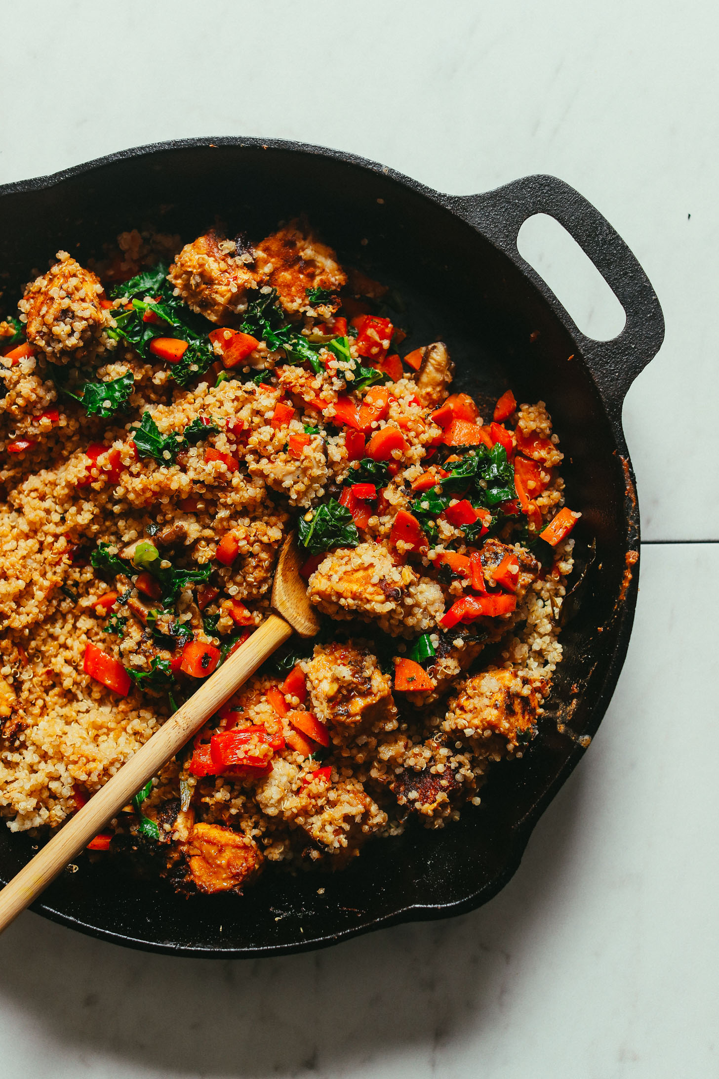 Overhead image of tempeh stir fry being sautéed in a cast iron pan