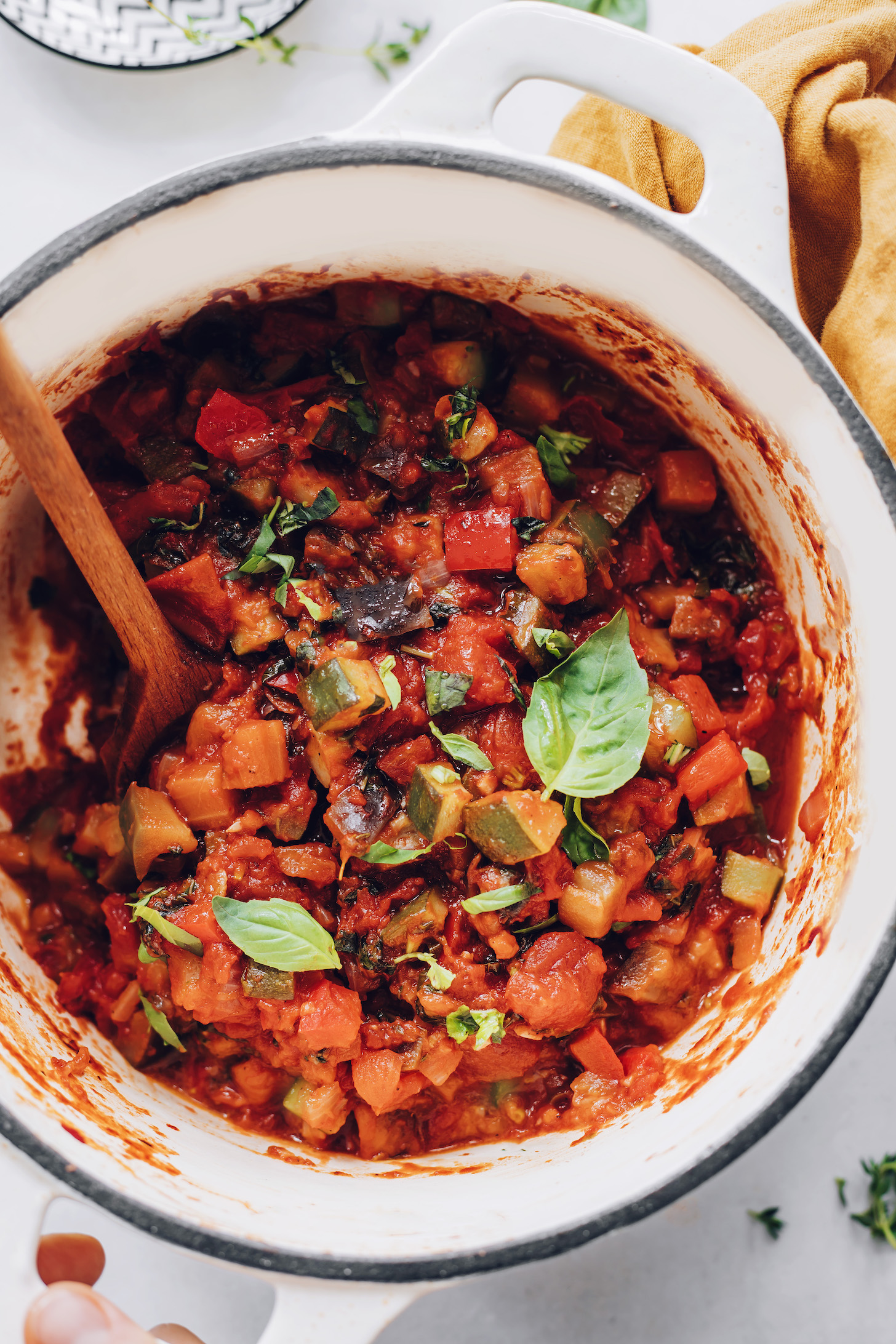 Big pot of vegan ratatouille topped with fresh basil