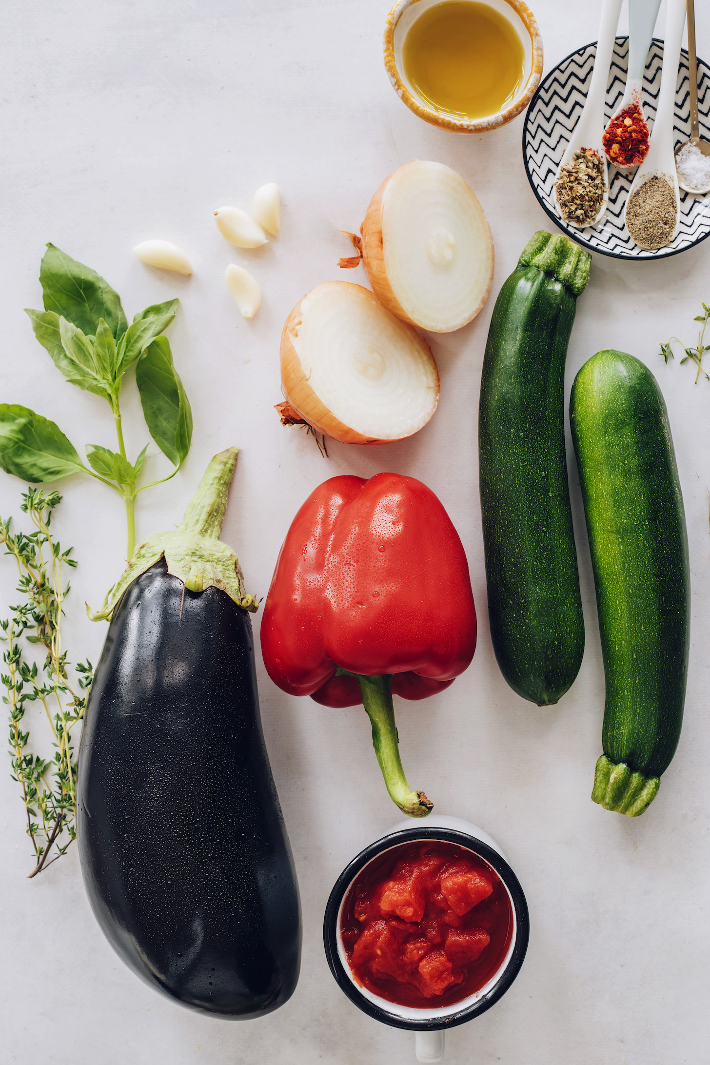 Basil, thyme, garlic, onion, eggplant, bell pepper, zucchini, tomatoes, oregano, red pepper flakes, salt, pepper, and olive oil