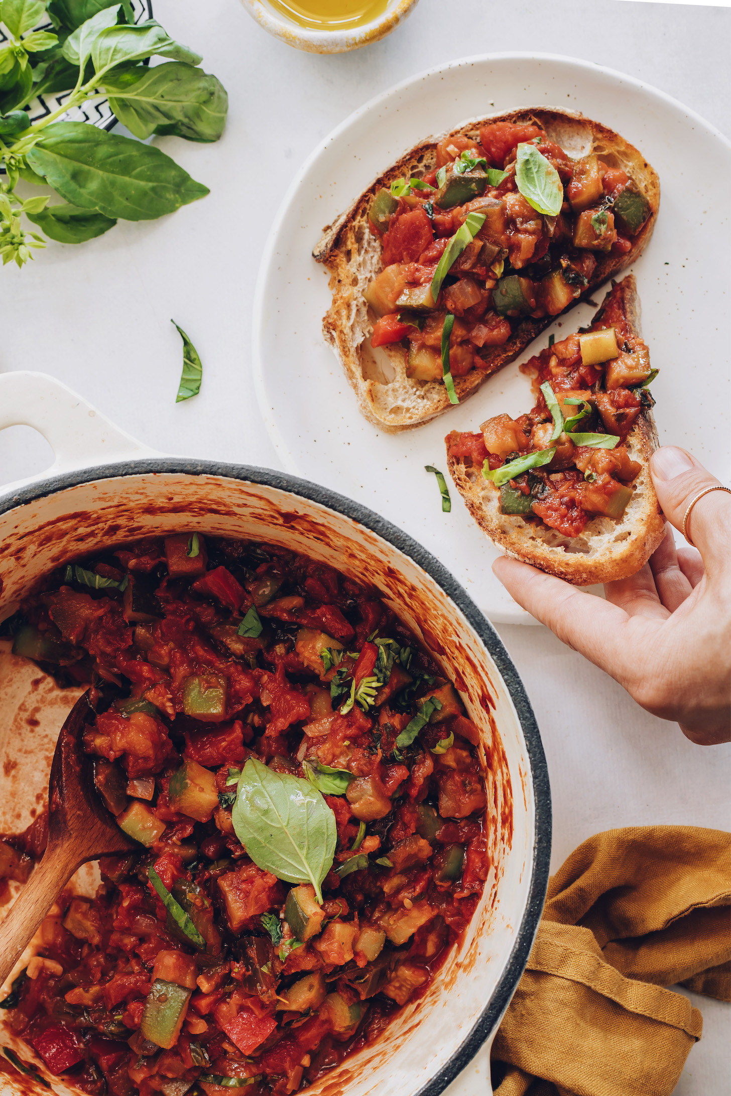 Pot of our easy ratatouille next to slices of bread topped with ratatouille