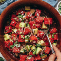 Vintage spoon in a bowl of watermelon salad with fresh cucumber and mint