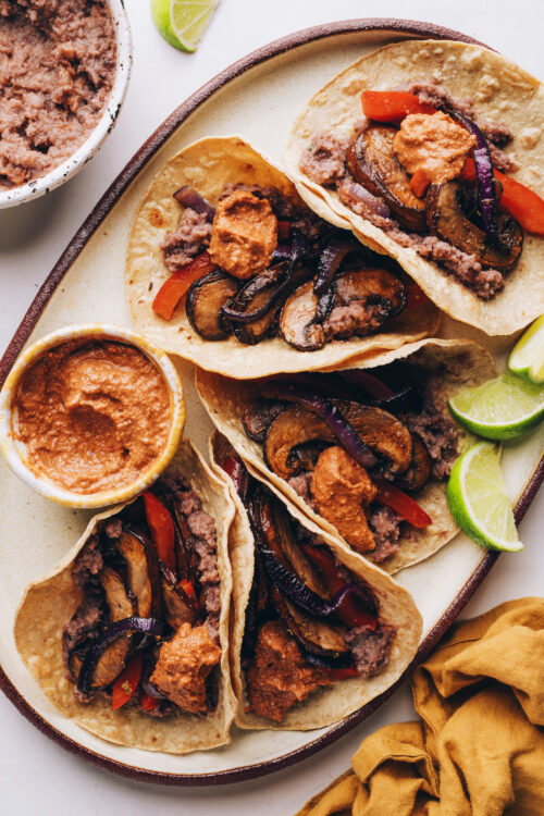 Platter of vegan fajitas with lime wedges