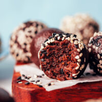 Close up shot of a partially eaten chocolate tahini truffle to show the inner texture