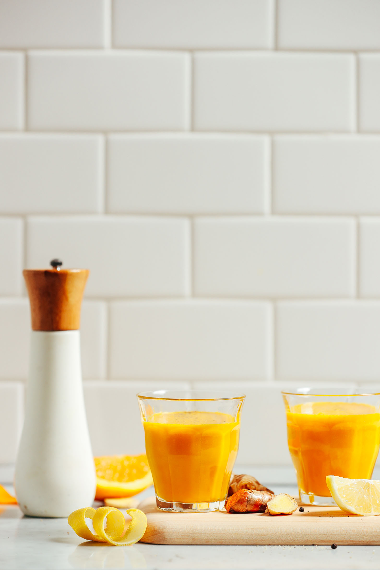 Two glasses of Turmeric Wellness Shots for an anti-inflammatory homemade juice