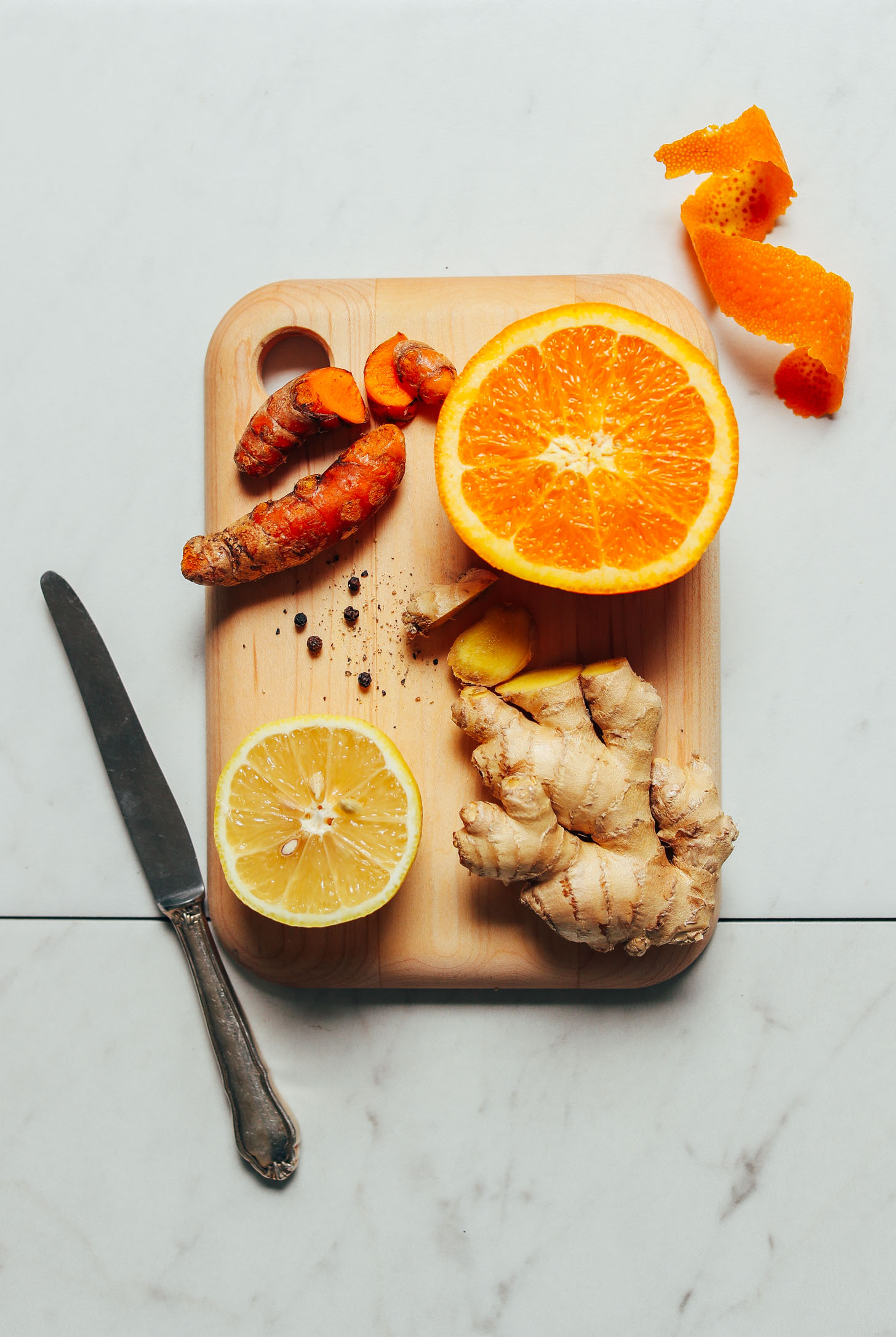 Fresh orange, turmeric, ginger, lemon and black pepper for making homemade wellness shots