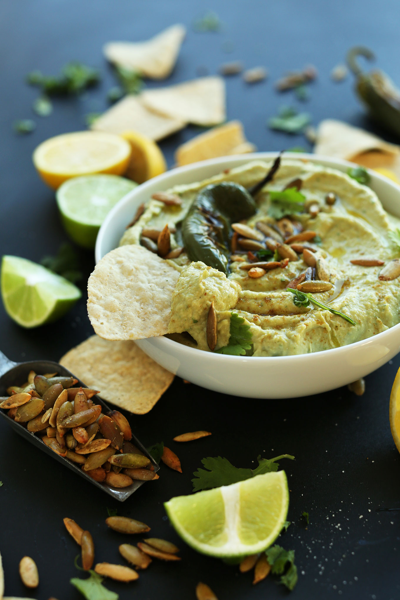 Close up shot of a bowl of Creamy Roasted Jalapeno Hummus topped with pumpkin seeds