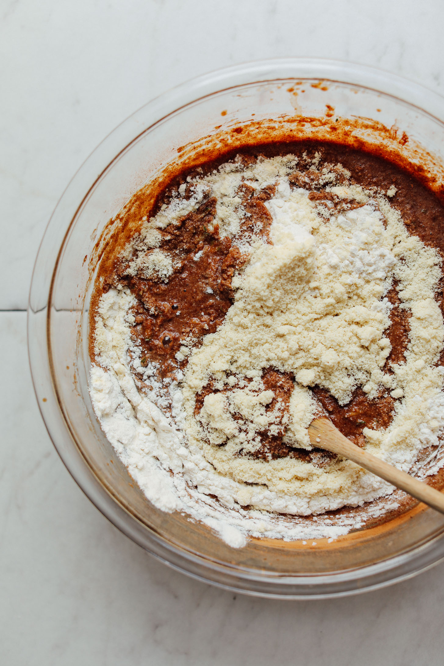 Stirring almond flour into mixing bowl of batter for delicious Vegan Chocolate Chip Zucchini Bread