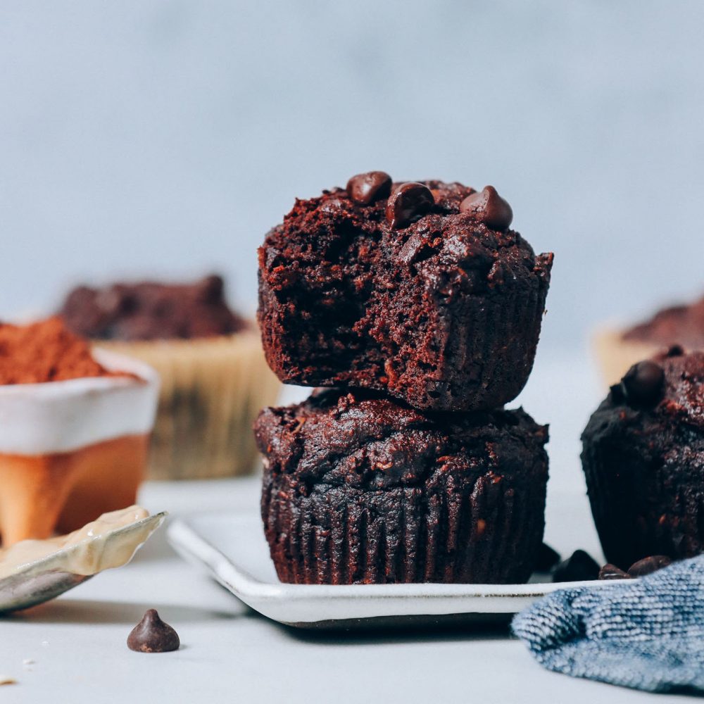 Tray with Banana Chocolate Muffins beside a spoonful of tahini and bowl of cocoa powder