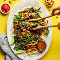 Using wooden spoons to pick up a serving of our Vegan Cauliflower Stir Fry recipe