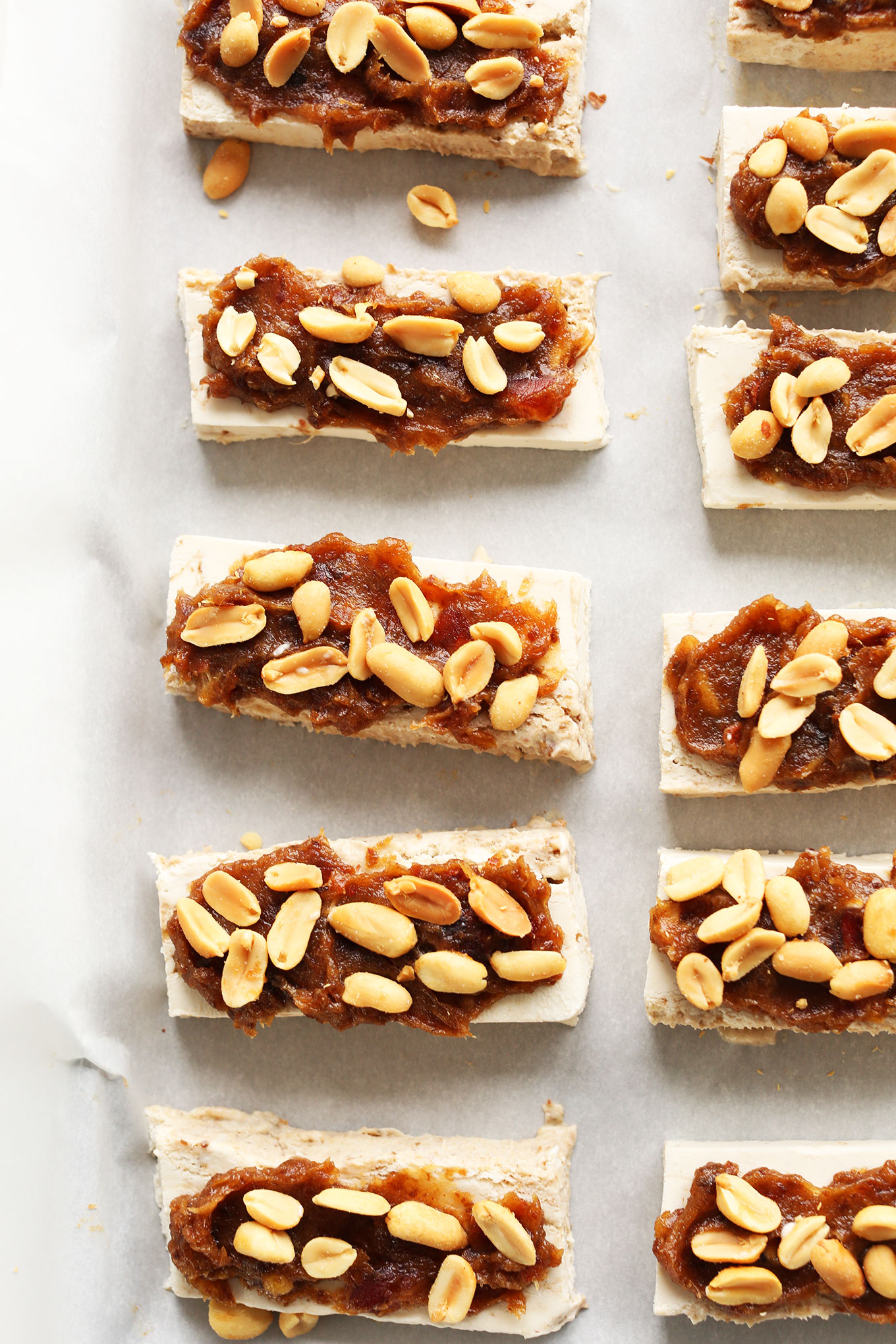 Parchment-lined pan filled with a batch of our Vegan Ice Cream Snickers Bar recipe