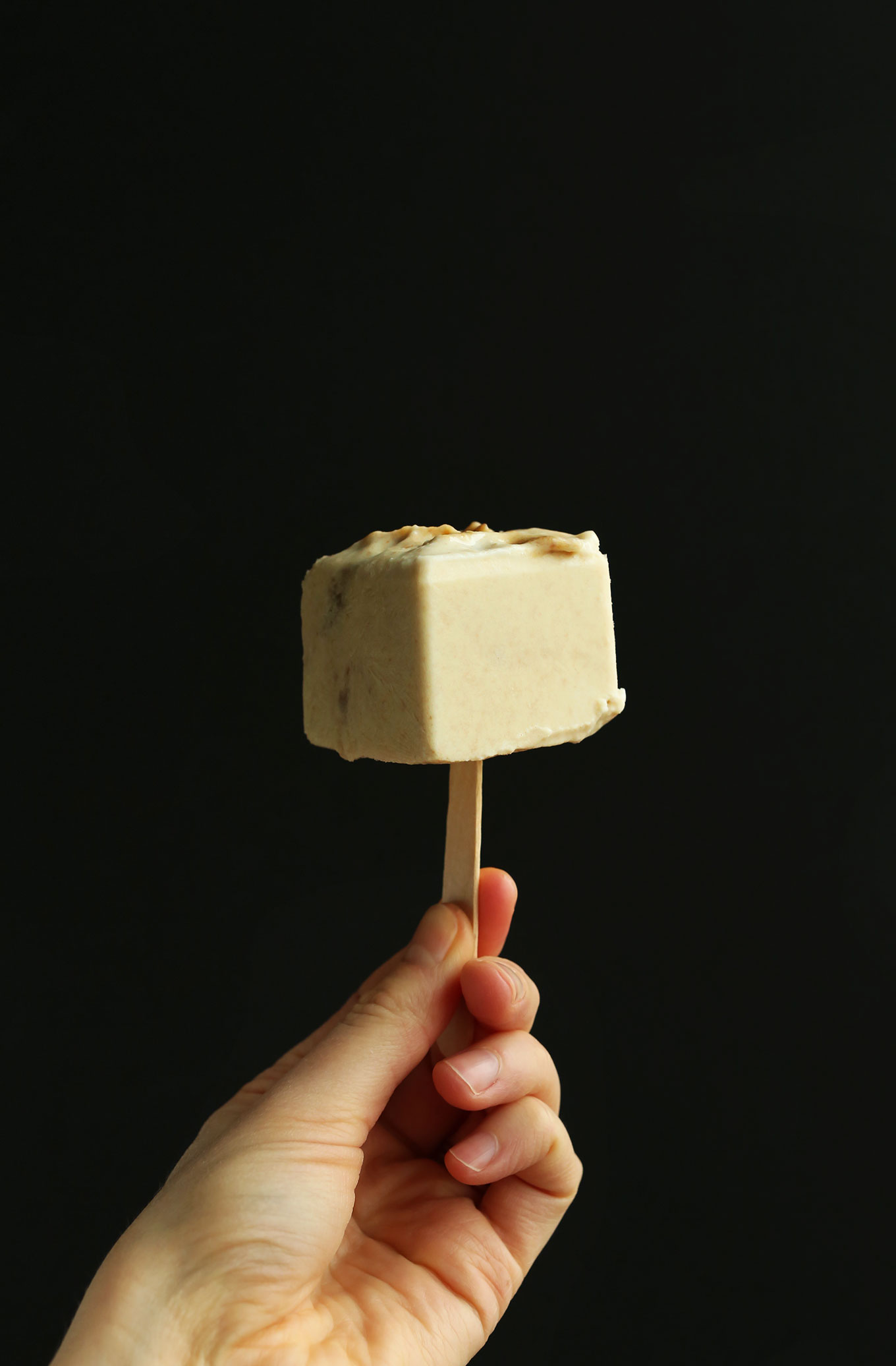 Holding up a Dulce De Leche Pop for an incredible vegan dessert