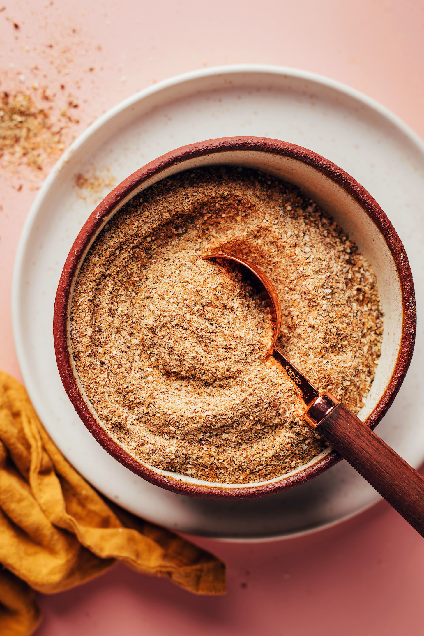 Overhead shot of a tablespoon in a bowl of our homemade Jamaican jerk seasoning recipe