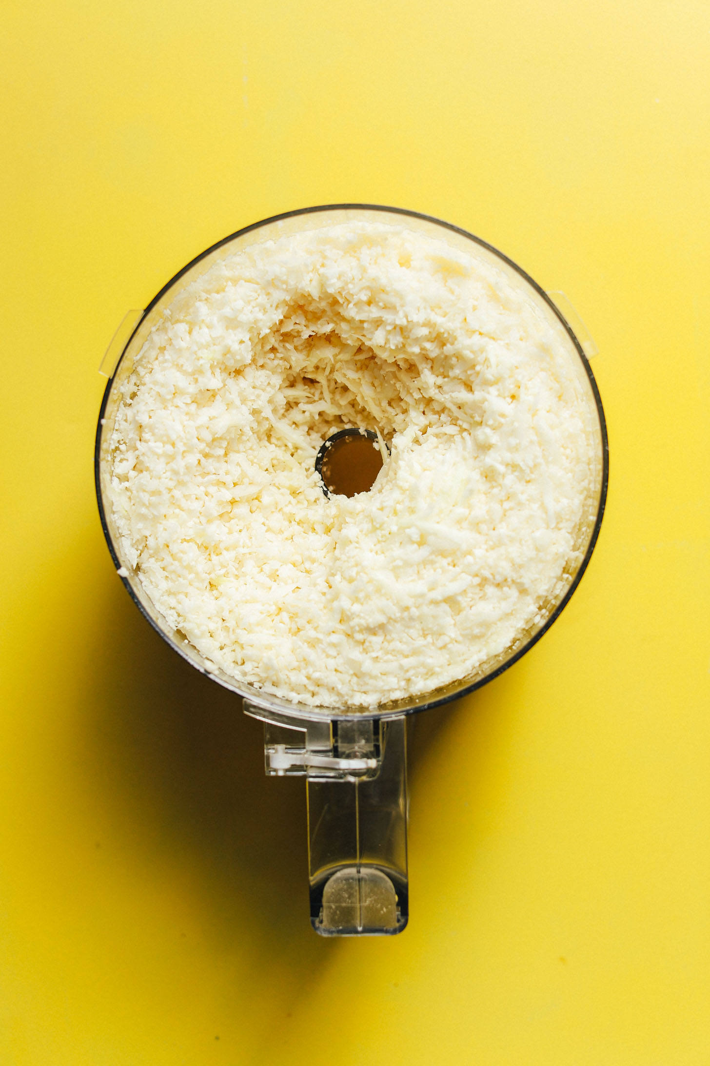 Food processor filled with riced cauliflower for Weeknight Cauliflower Rice Stir Fry