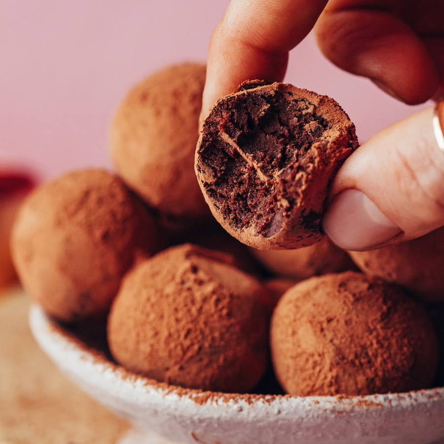 Holding a dark chocolate sweet potato truffle