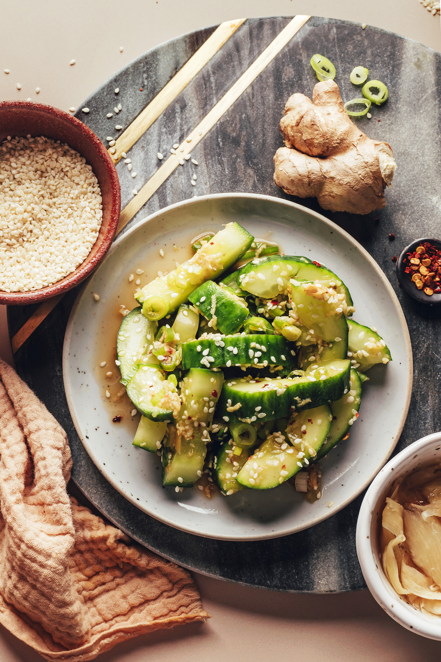 Small plate of smashed cucumber salad topped with sesame seeds