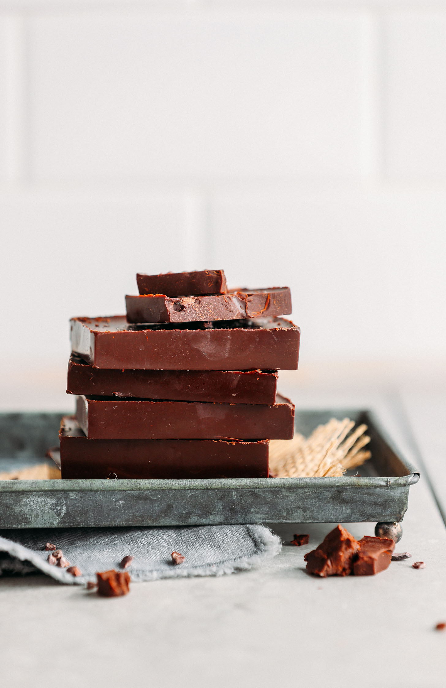 A stack of DIY Vegan Dark Chocolate bars on a metal serving platter