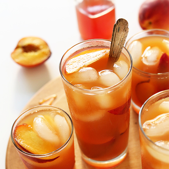 Glasses of our Perfect Peach Iced Tea with peach slices and ice cubes in them