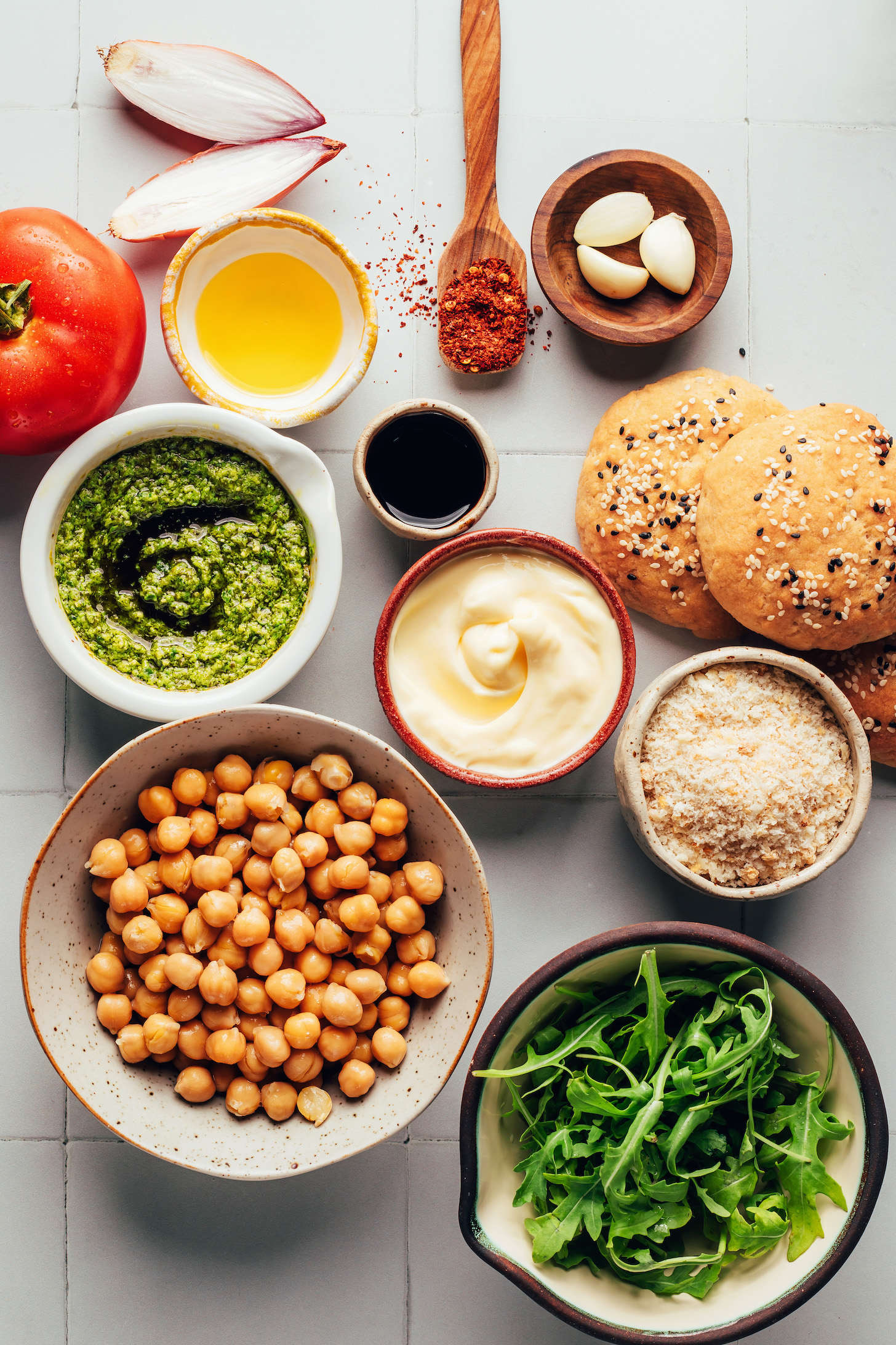 Tomato, shallot, olive oil, red pepper flakes, garlic, balsamic vinegar, vegan mayo, buns, breadcrumbs, arugula, and chickpeas