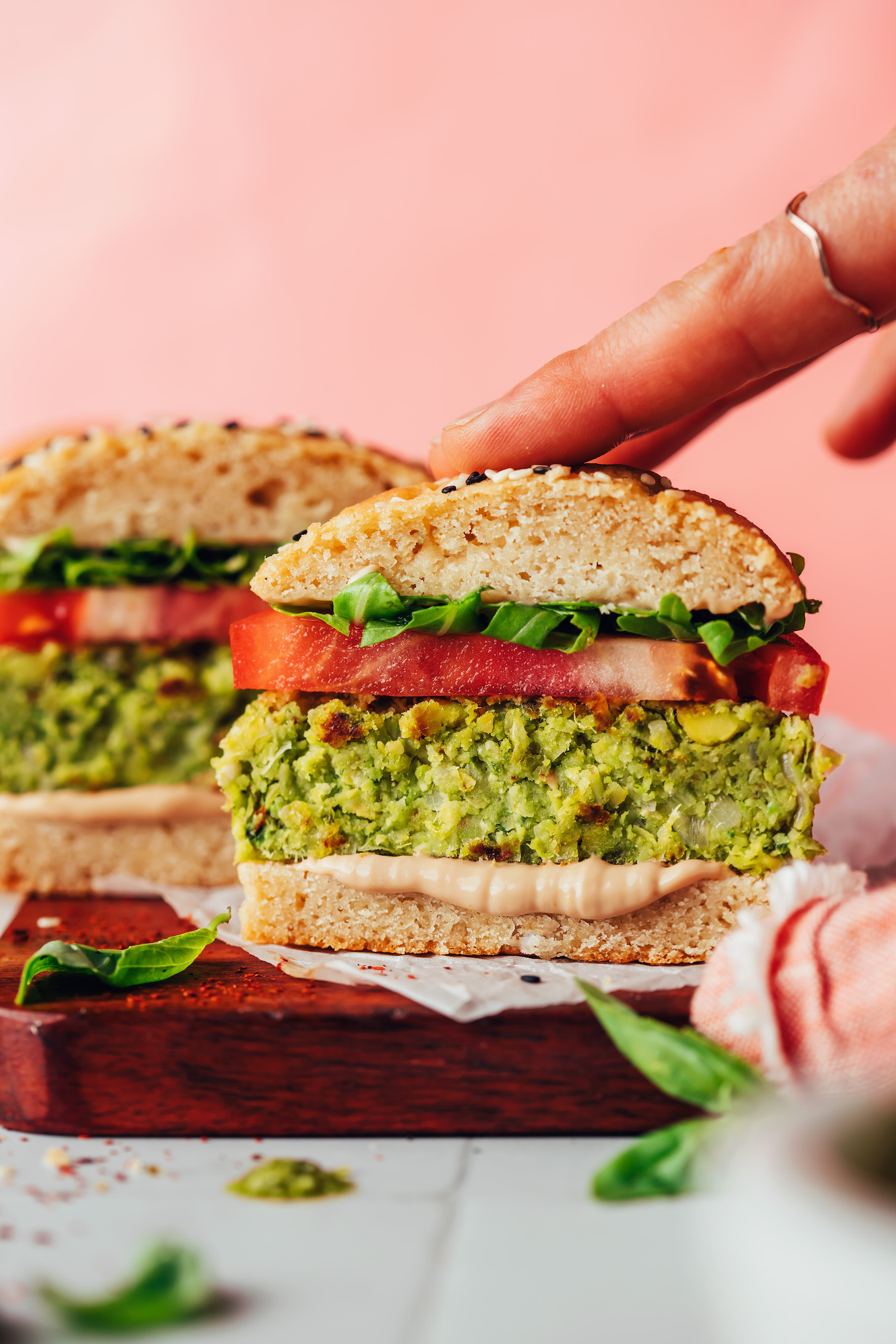 Pressing down on the top of a pesto veggie burger