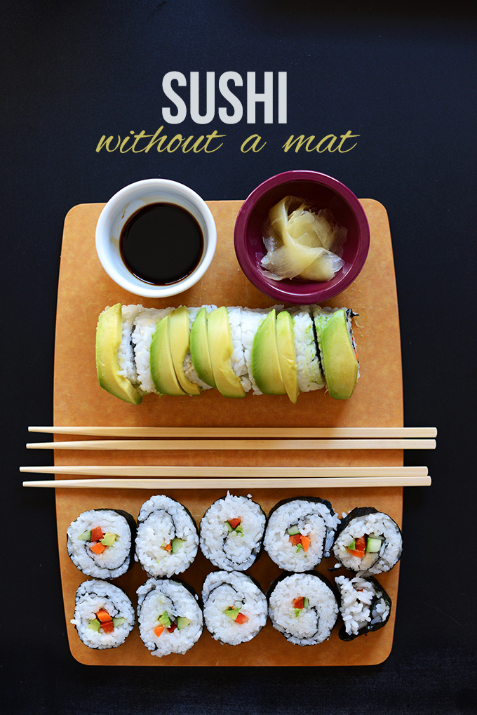 Wood board with sushi rolls, pickled sushi ginger, and soy sauce for our tutorial on How to Make Sushi