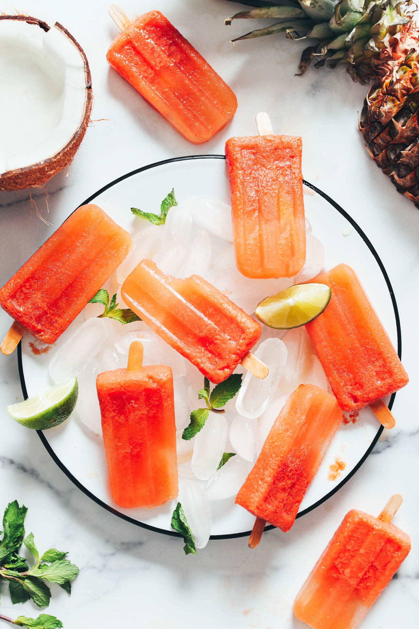 Lime wedges and mint leaves on a plate with homemade fruit popsicles