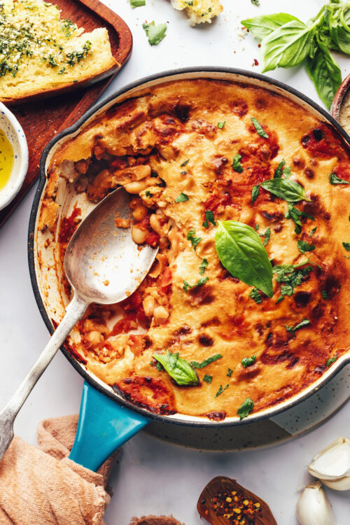 Large spoon in a pan of cheesy pizza beans