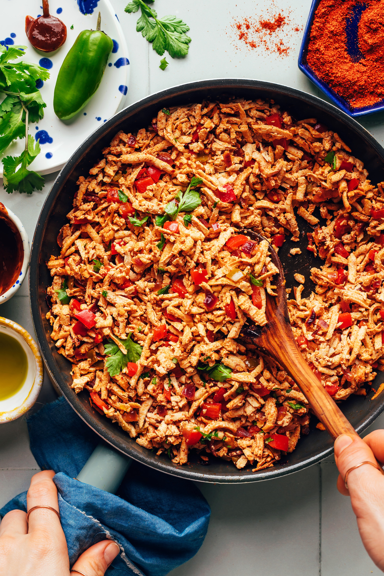 Stirring a skillet of vegan shredded tofu taco meat