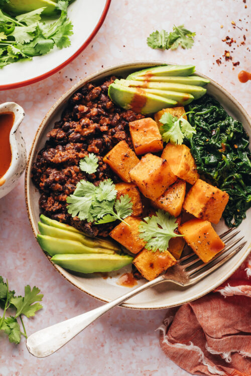 Fork resting in a butternut squash and black bean breakfast bowl