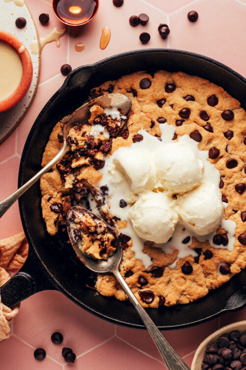 Scoops of vanilla ice cream on a tahini chocolate chip skillet cookie