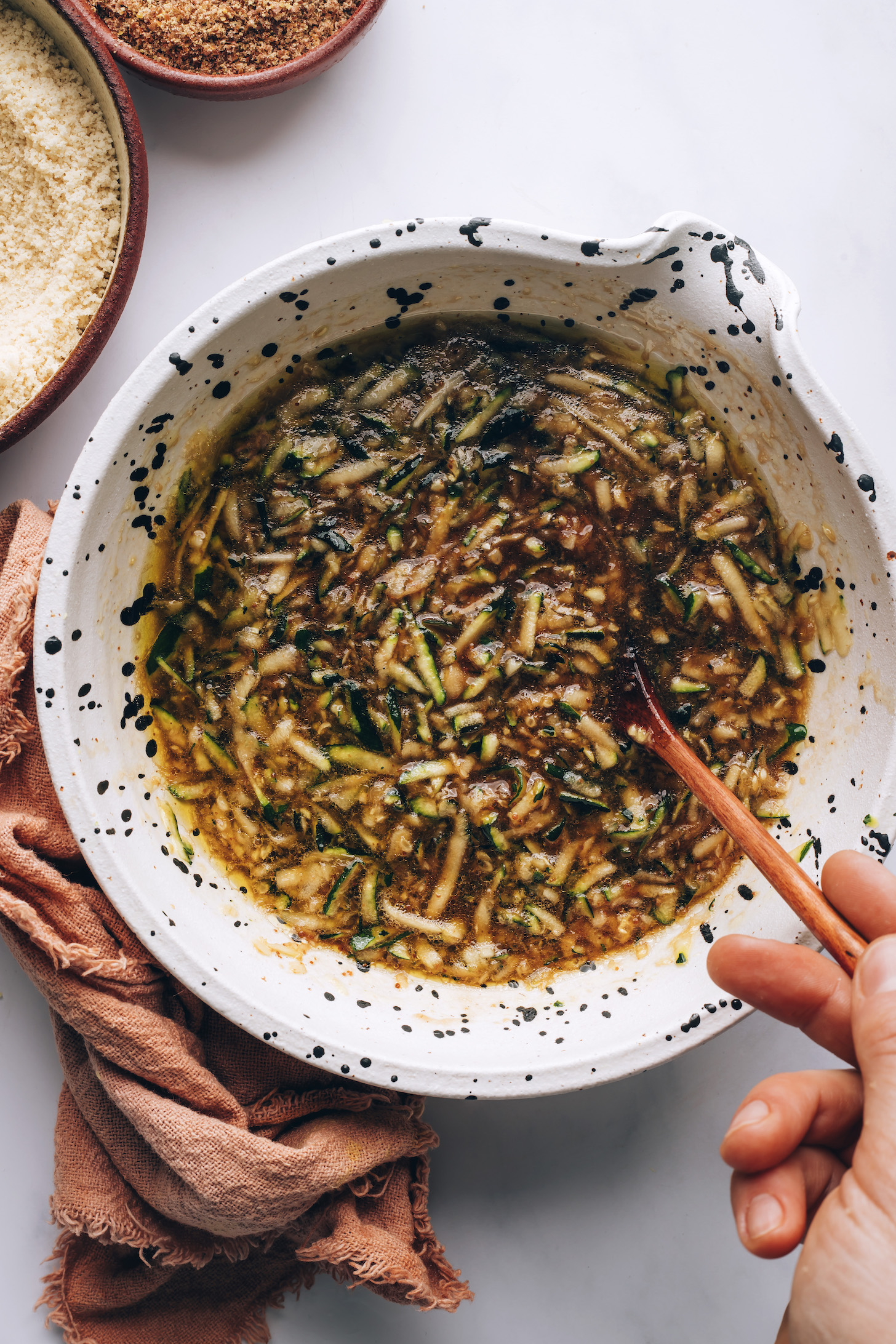 Mixing bowl with shredded zucchini and other wet ingredients