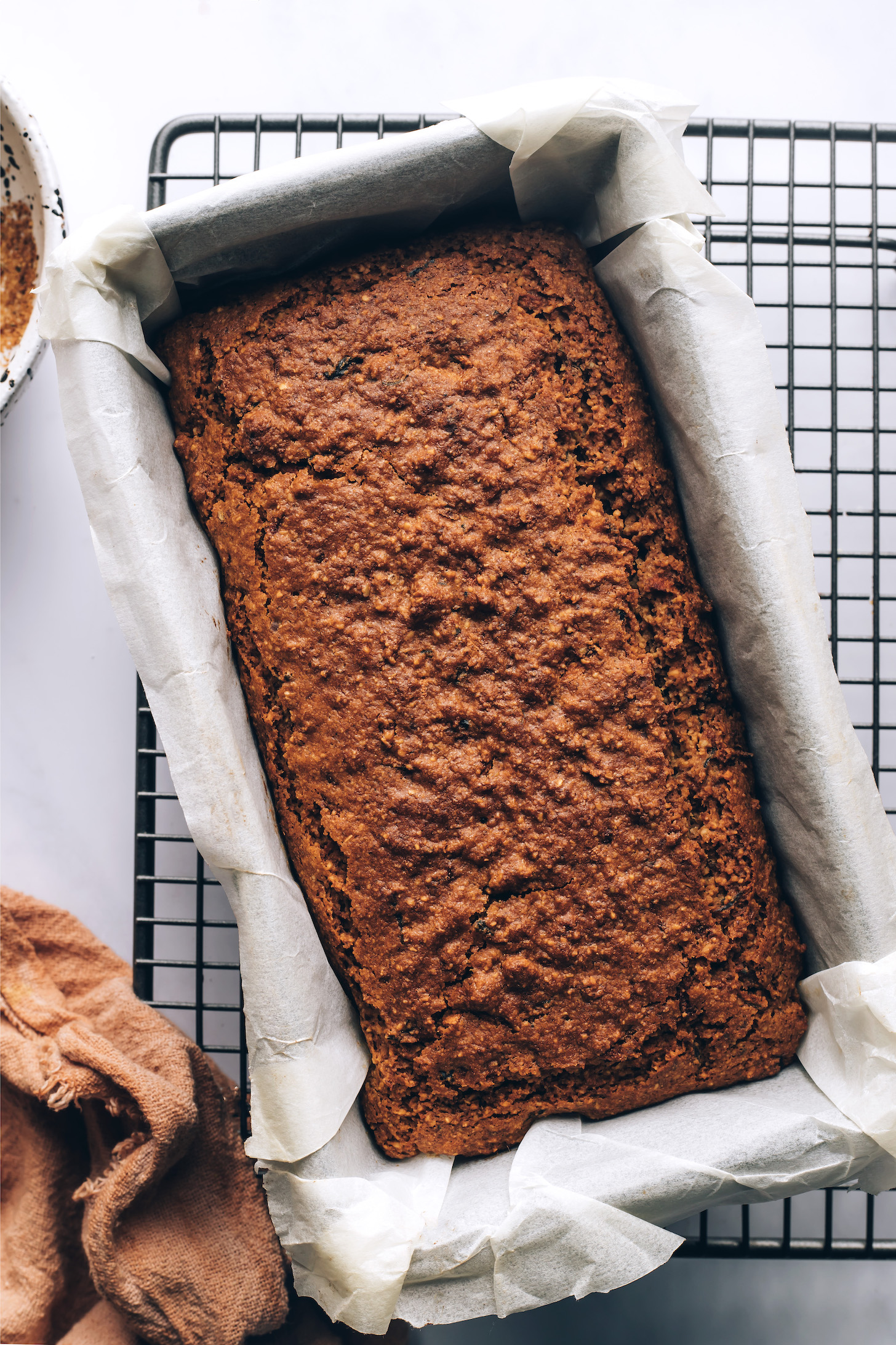 Loaf pan of baked zucchini bread on a cooling rack