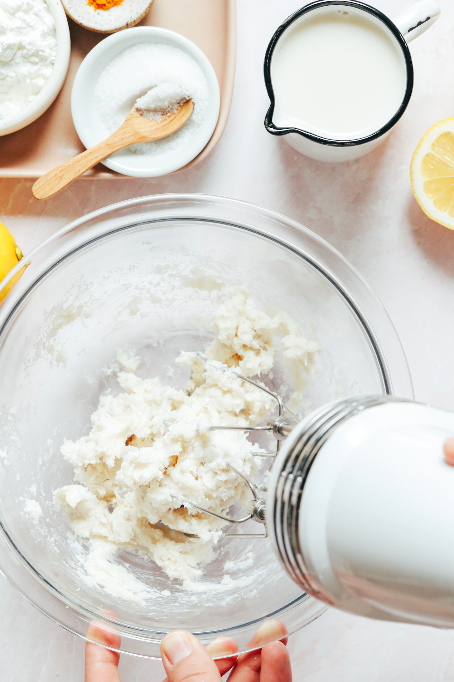 Using a hand mixer to beat together cane sugar and vegan butter