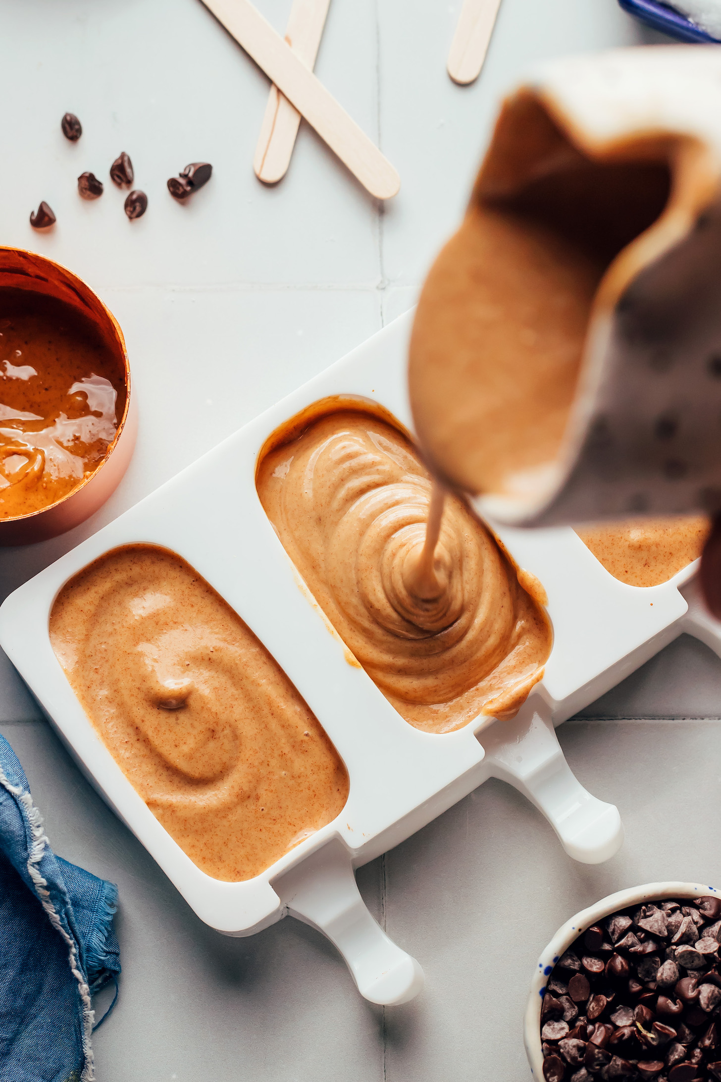 Pouring a creamy peanut butter mixture into an ice cream mold