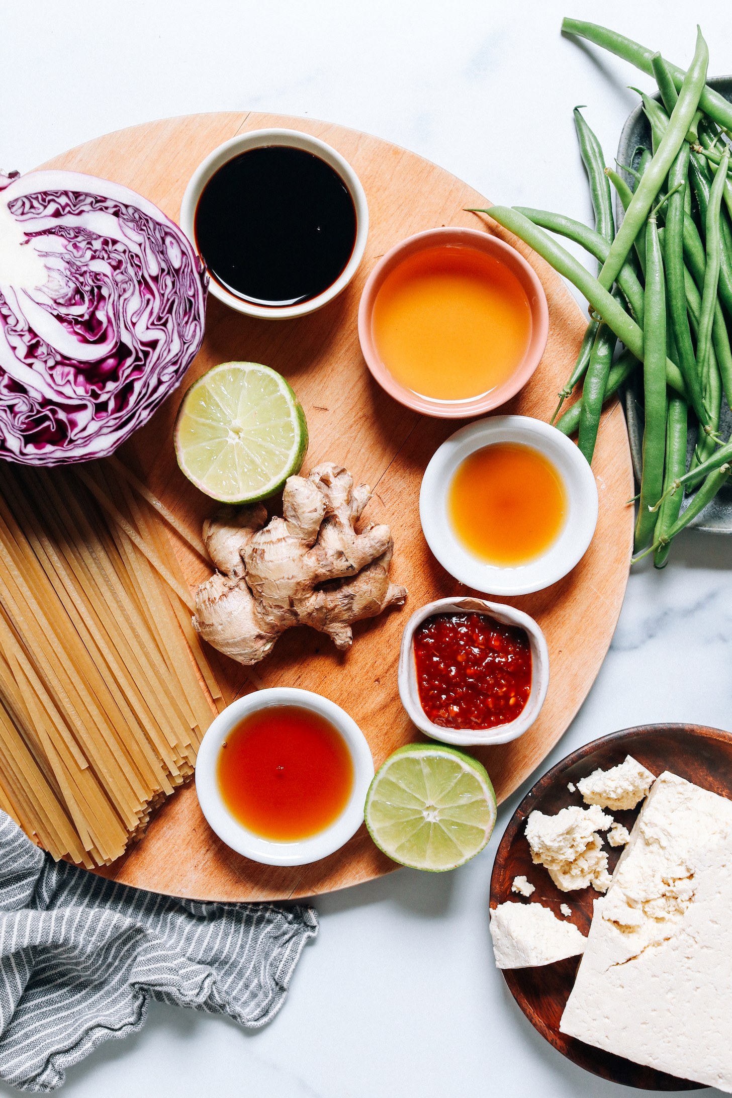 Red cabbage, brown rice noodles, maple syrup, lime, tofu, chili garlic sauce, sesame oil, toasted sesame oil, green beans, and tamari