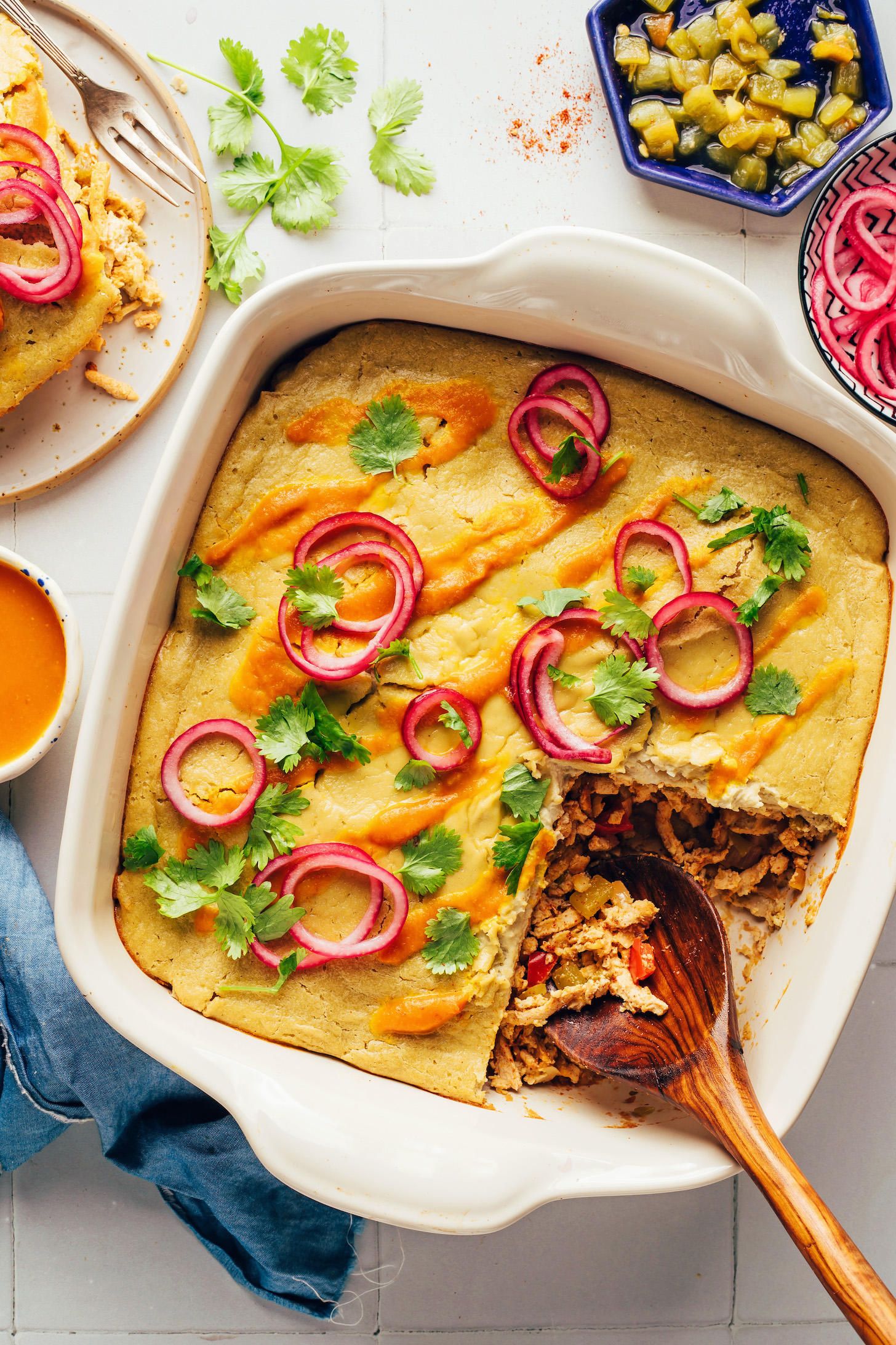 Overhead shot of a spoon resting in a pan of creamy vegan green chile casserole