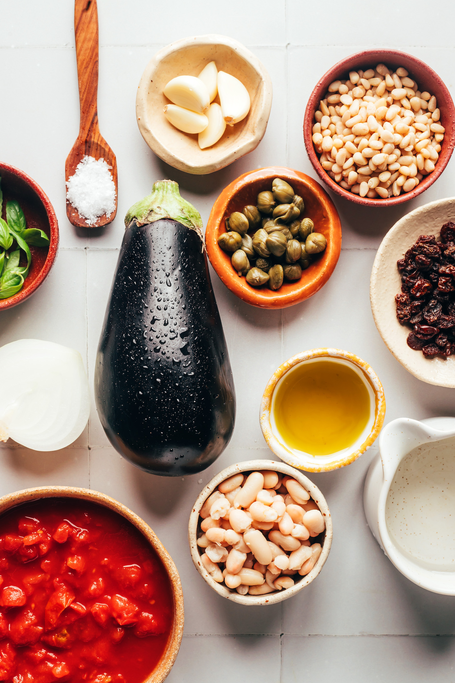 Basil, salt, garlic, pine nuts, raisins, capers, eggplant, onion, olive oil, water, white beans, and crushed tomatoes